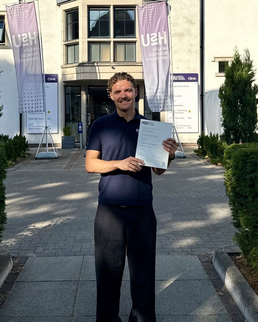 Ásbjörn Ingvarsson, Master of Chiropractic graduate and founder of ThatChiro, holding his degree